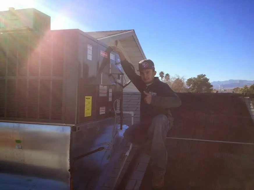 HVAC technician performing AC Tune-Up on a rooftop unit in Colville